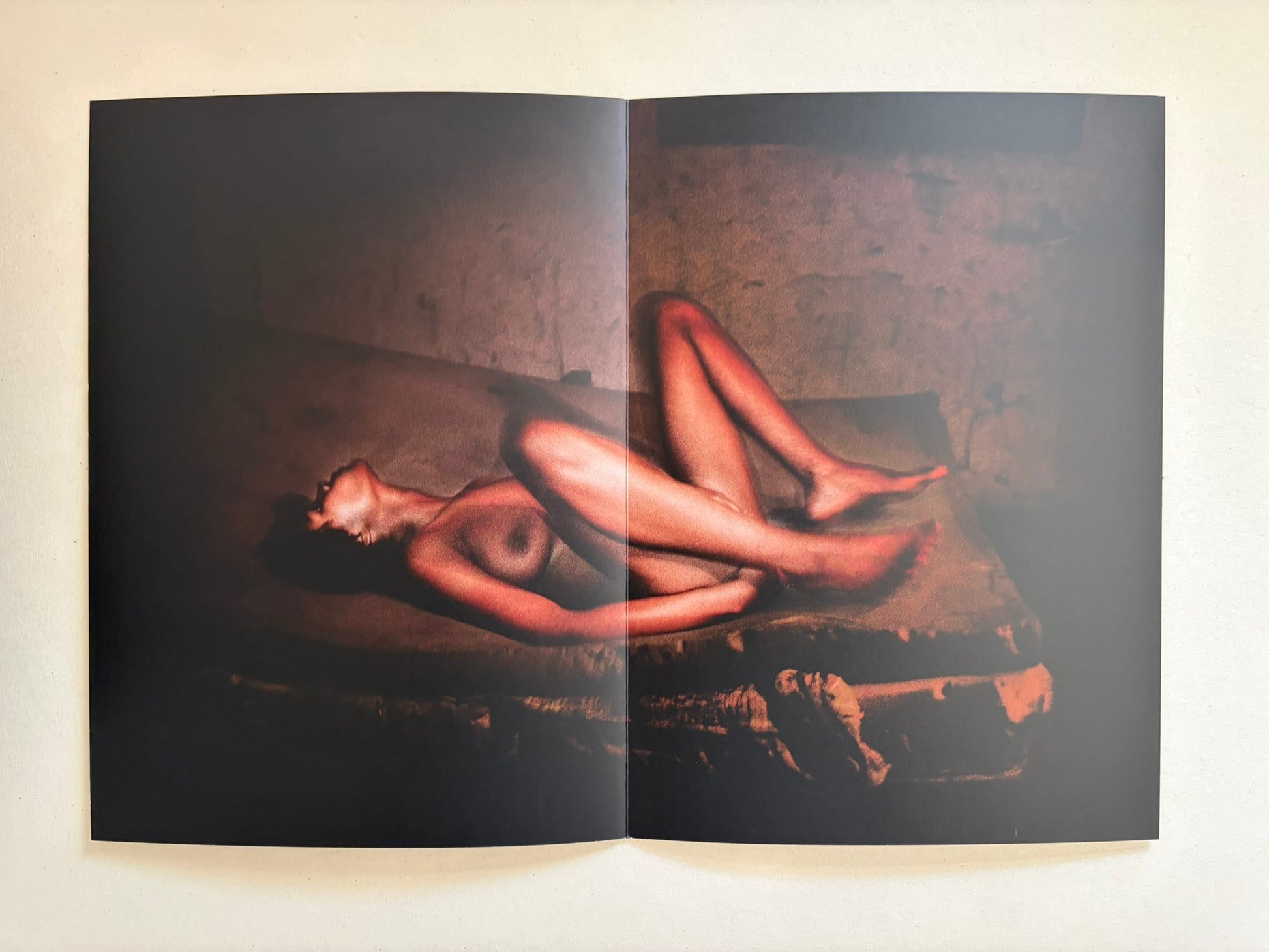 A spread from Cidade de Pedra showing a nude figure lying on a bed.