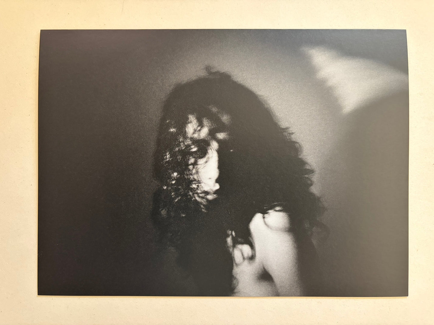 A blurred black-and-white portrait of a person with dark hair from Cidade de Pedra.