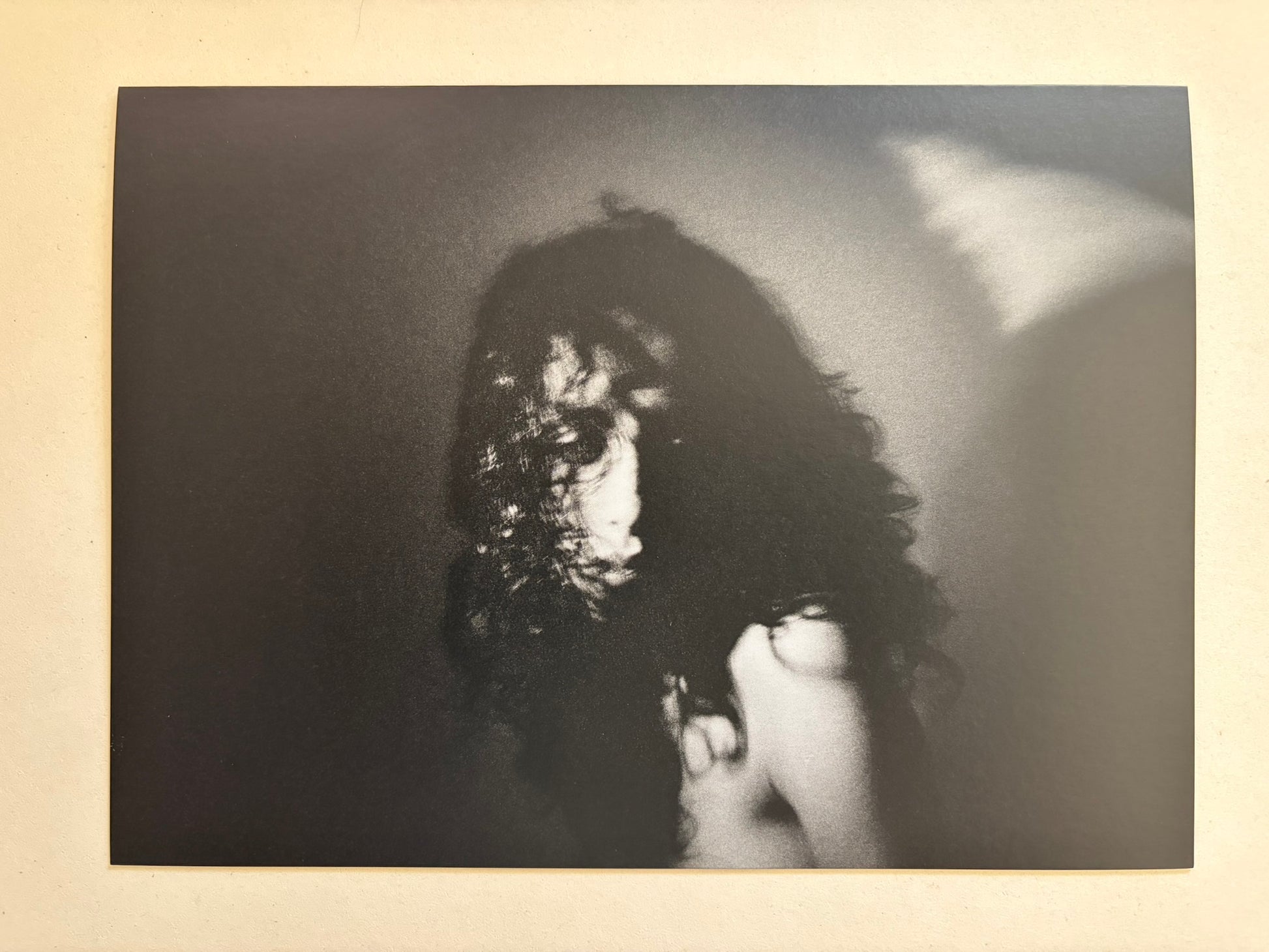 A blurred black-and-white portrait of a person with dark hair from Cidade de Pedra.
