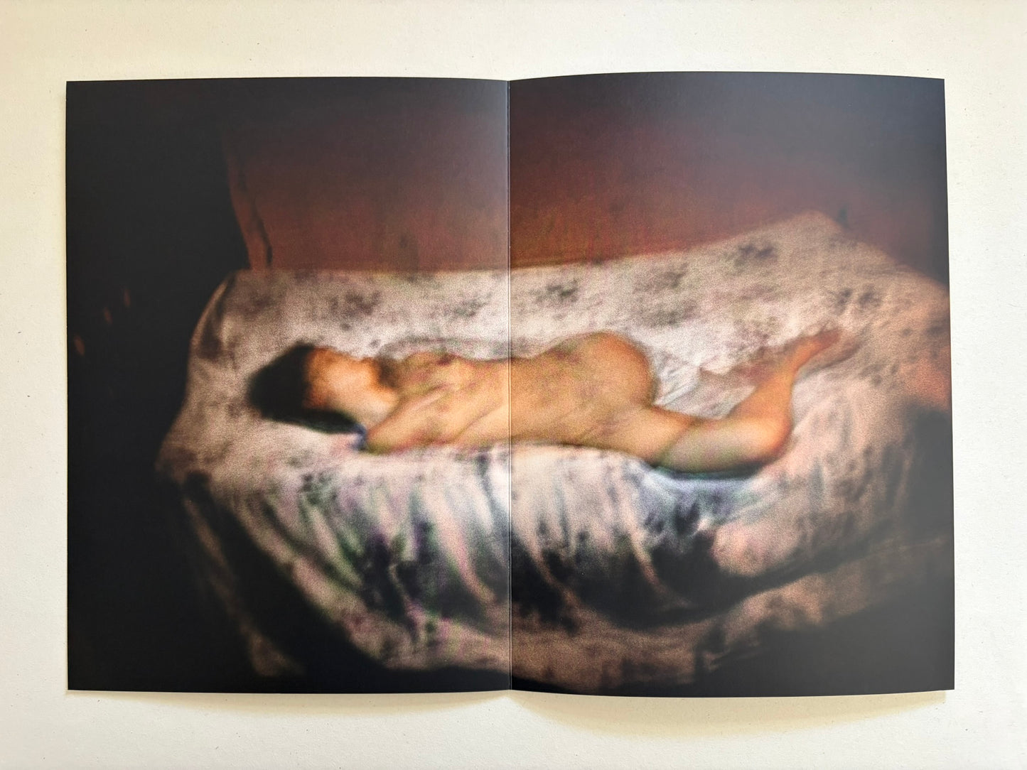 A spread from Cidade de Pedra showing a nude figure lying on a patterned mattress.