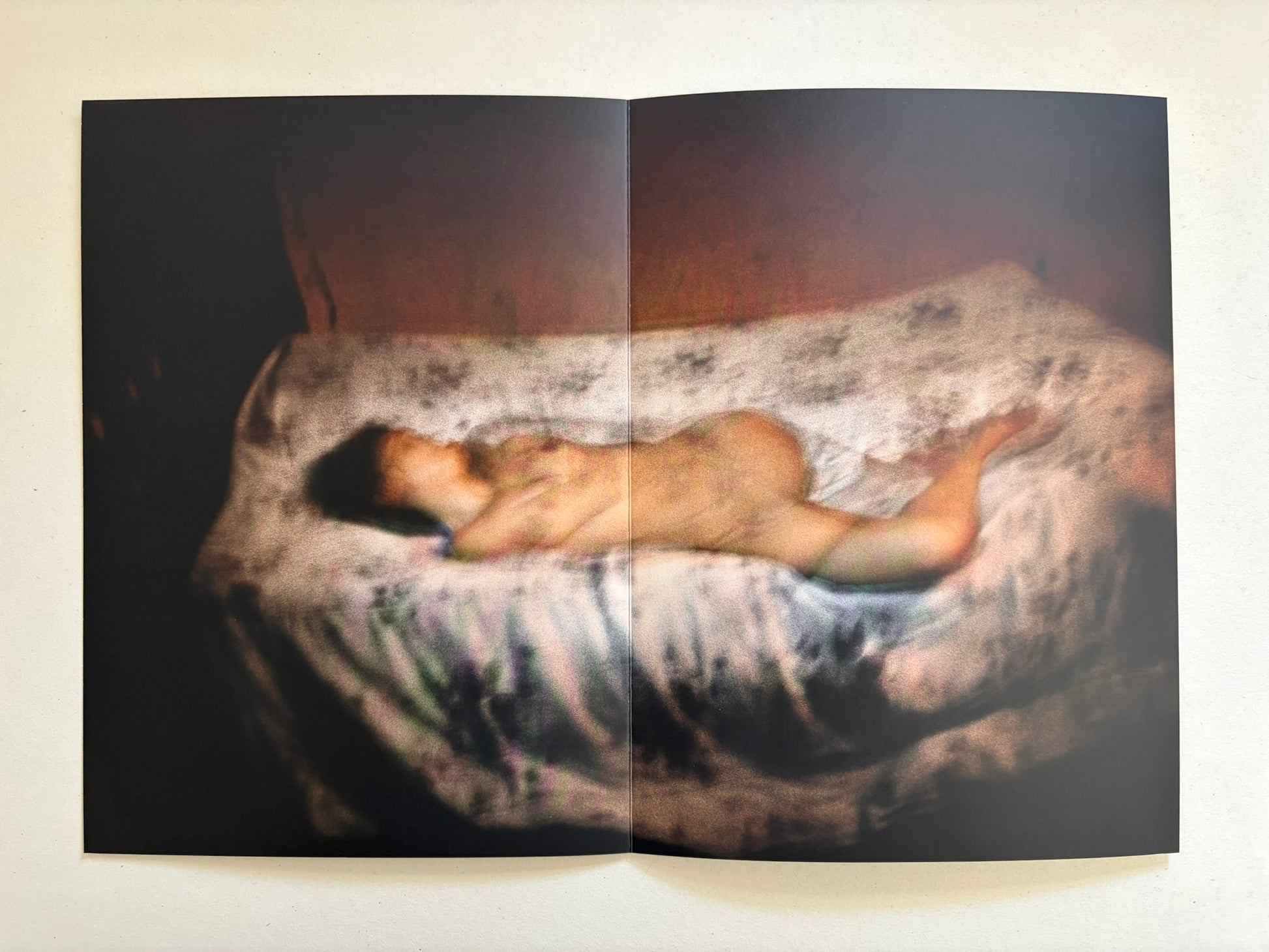 A spread from Cidade de Pedra showing a nude figure lying on a patterned mattress.