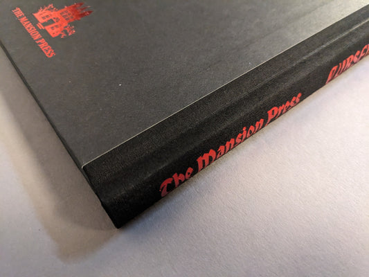 Close-up of the cloth spine with red foiled The Mansion Press imprint.
