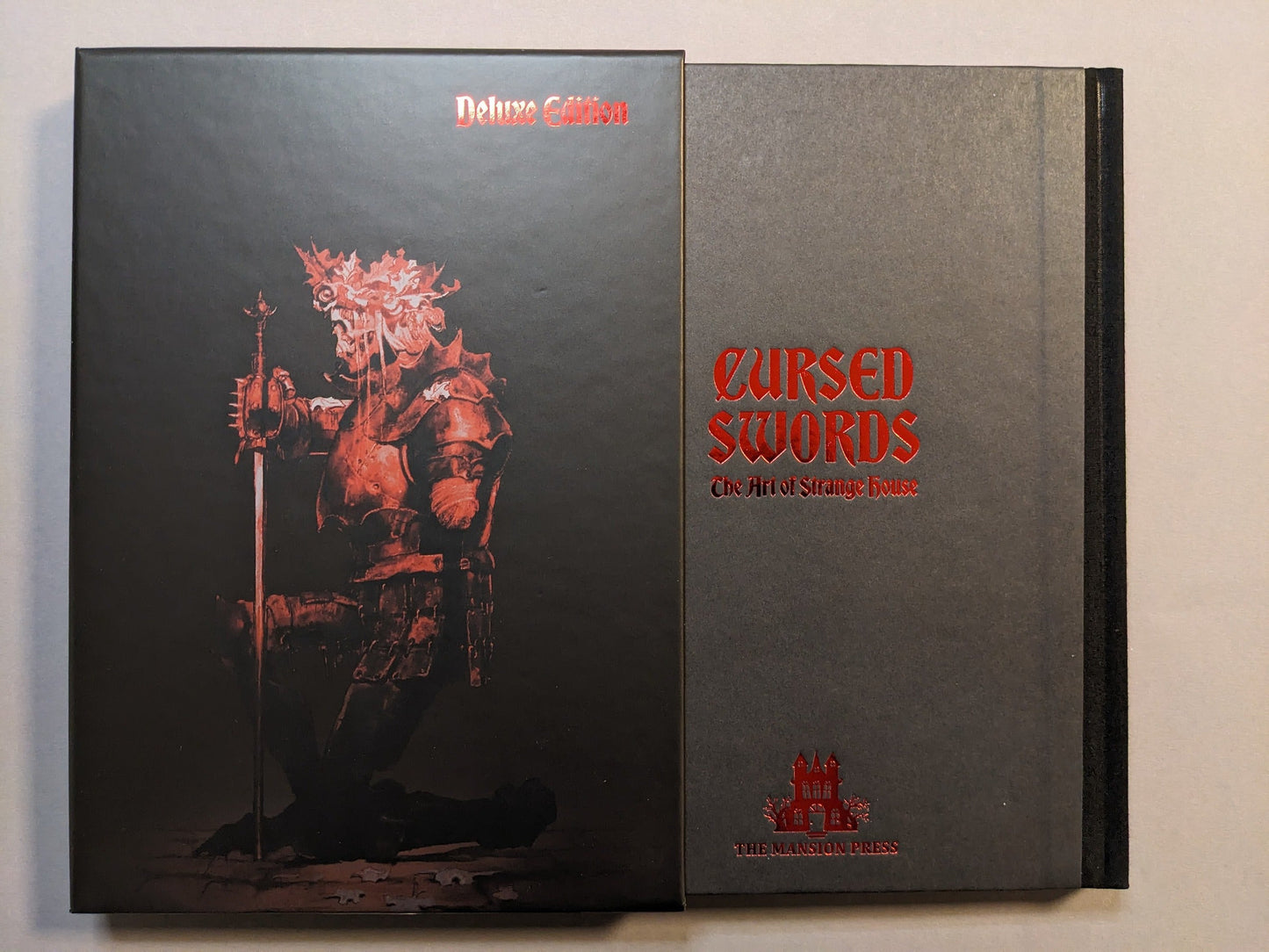 Set view of Cursed Swords — Deluxe Slipcase Edition: hardcover book alongside matching slipcase; limited to 499 copies.