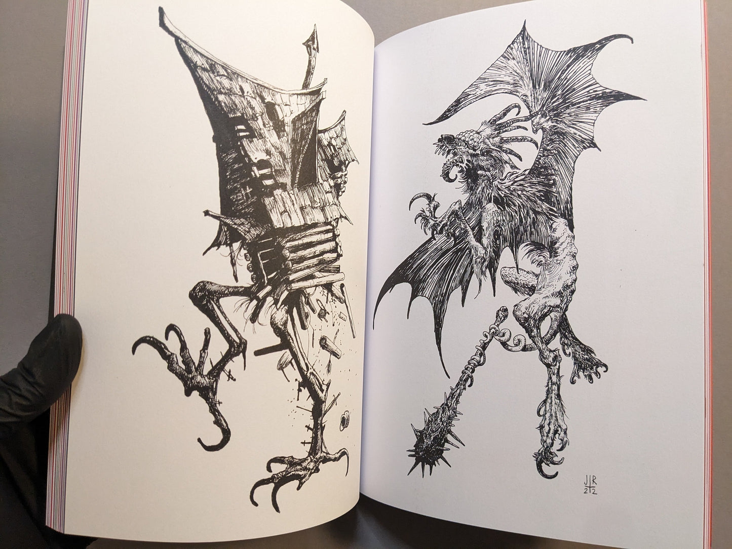 Interior spread with intricate black-ink drawings: a winged bestial creature and a house-like golem figure.