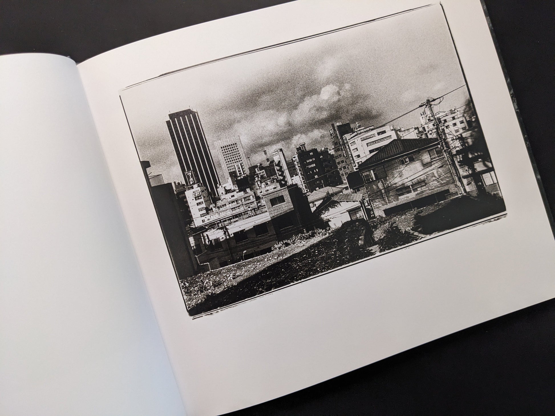 Urban landscape photograph from 1980s Remnants by Daido Moriyama with high-rise buildings and open lot