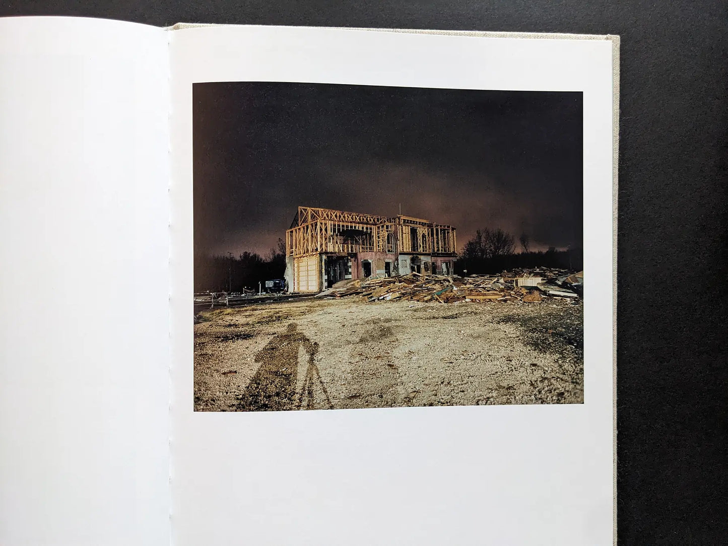 Color night view of a house façade under construction on the set; the photographer’s tripod shadow is visible.