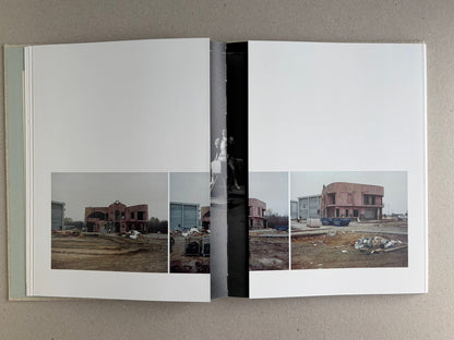 Gatefold spread in Dear God, the Parthenon is still broken, showing a panoramic city view across the pages with a narrow central strip.