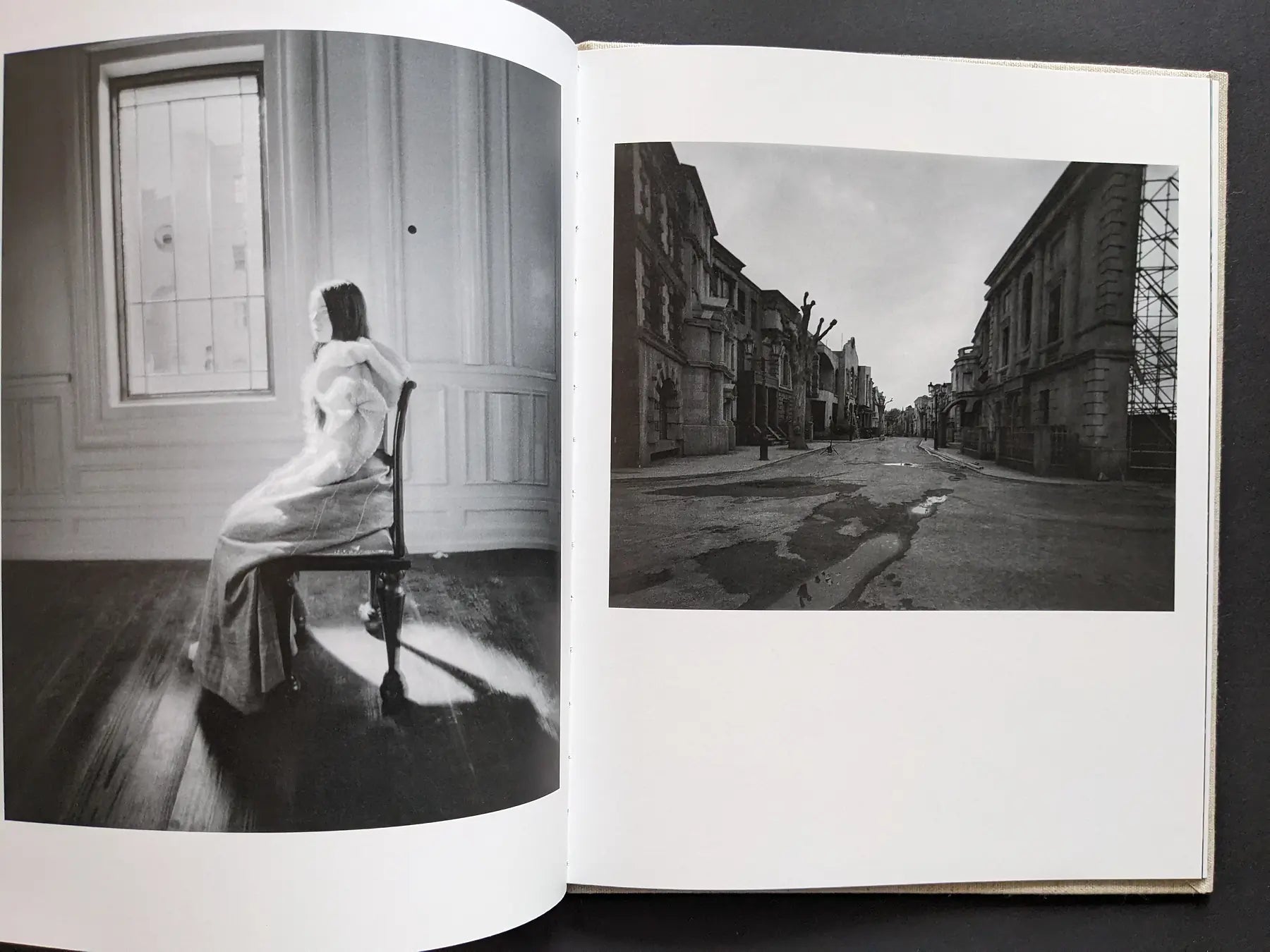 Spread with a woman seated by a bright window and a deserted studio backlot street.