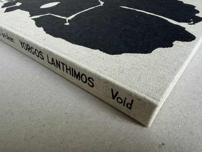 Close view of the cloth spine of Dear God, the Parthenon is still broken by Yorgos Lanthimos, with the title and Void printed in black.