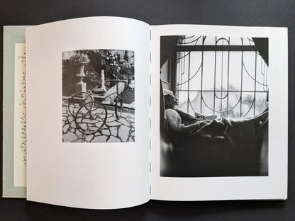 Black-and-white photographs of a tricycle and a resting figure by a window.