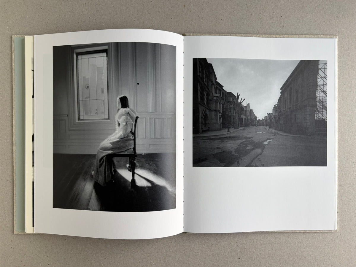 Black-and-white spread with a seated woman on the left and a street scene on the right in Dear God, the Parthenon is still broken.