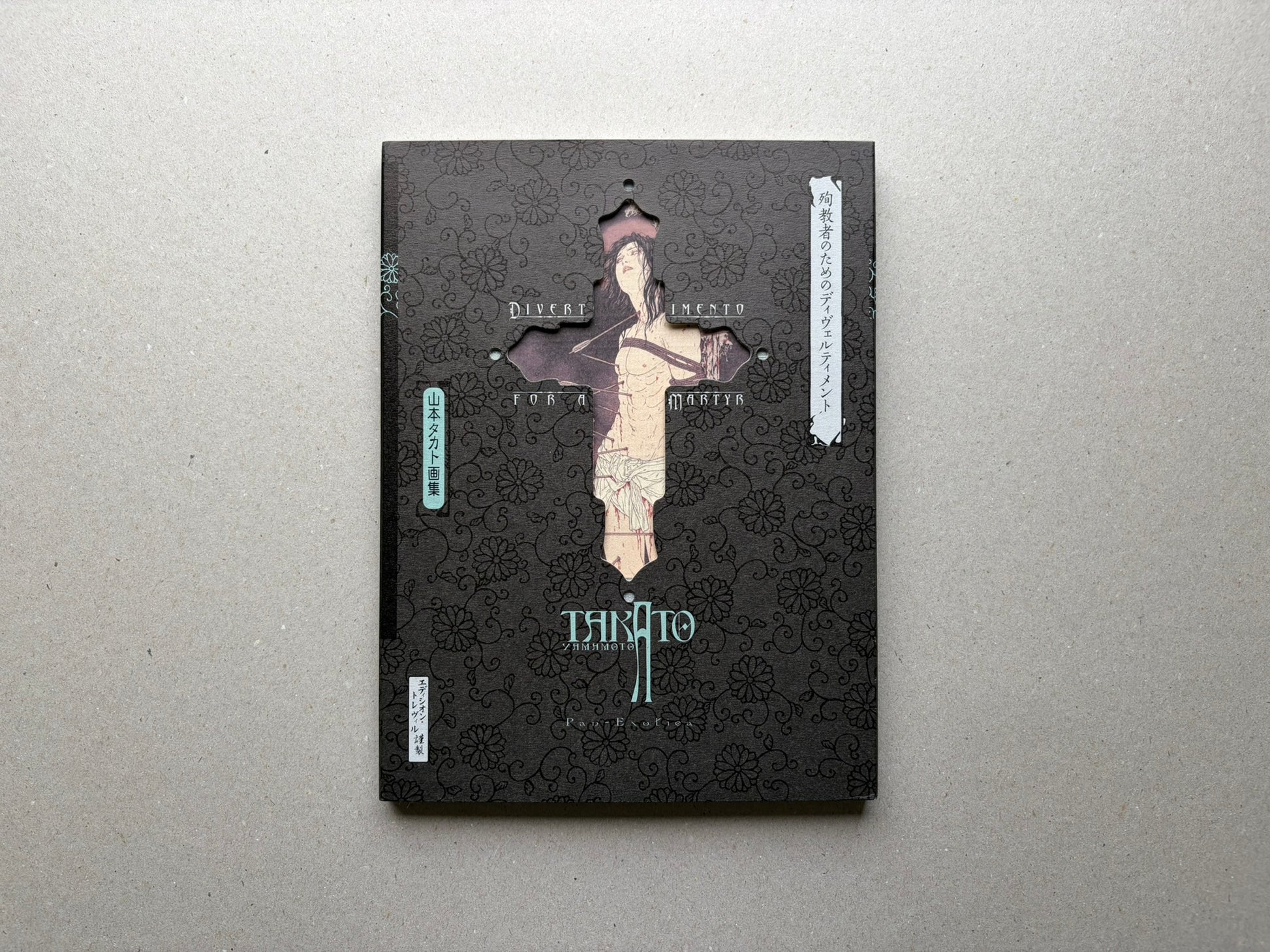 Divertimento for a Martyr – Takato Yamamoto New Black Edition, front cover with black patterned sleeve and cross-shaped cutout