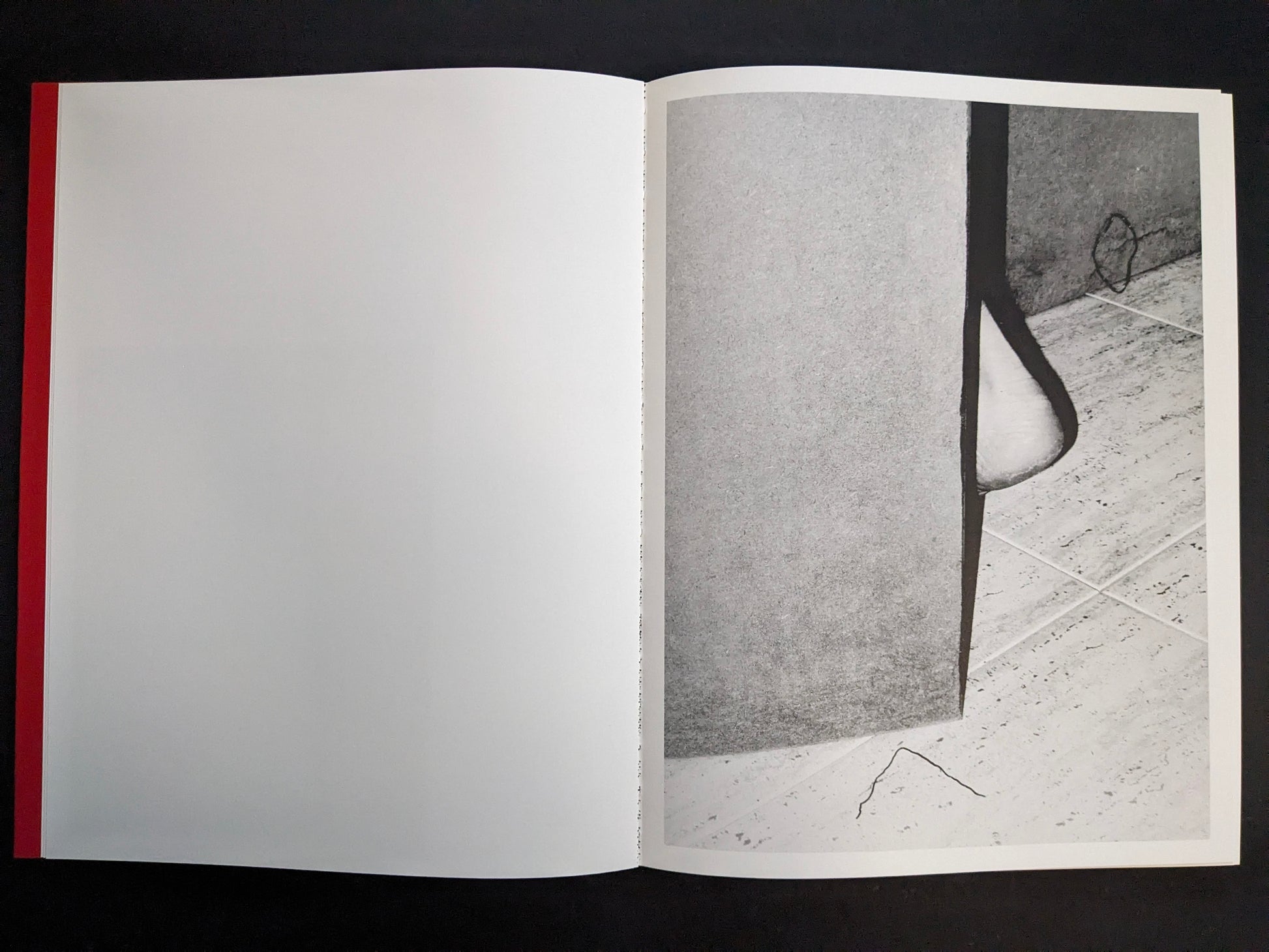 Interior spread with a monochrome photograph of a doorway edge, tiled floor, and a partially visible shoe.