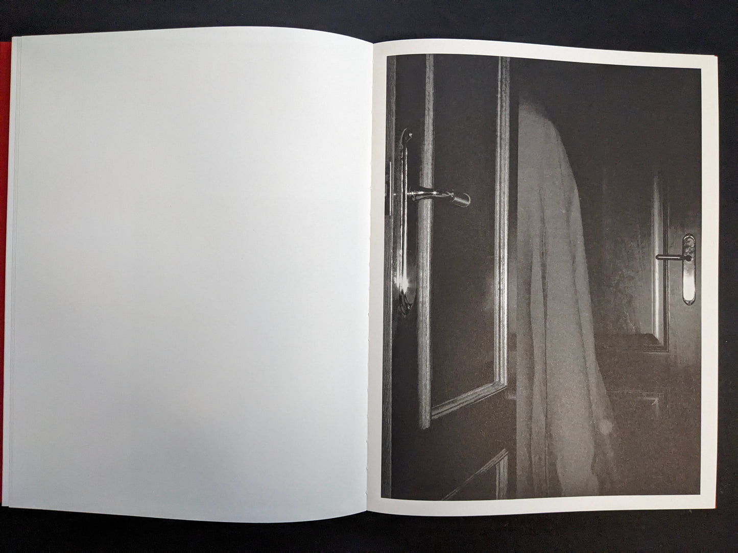 Interior page with a monochrome photograph of a doorway with a hanging cloth or garment.