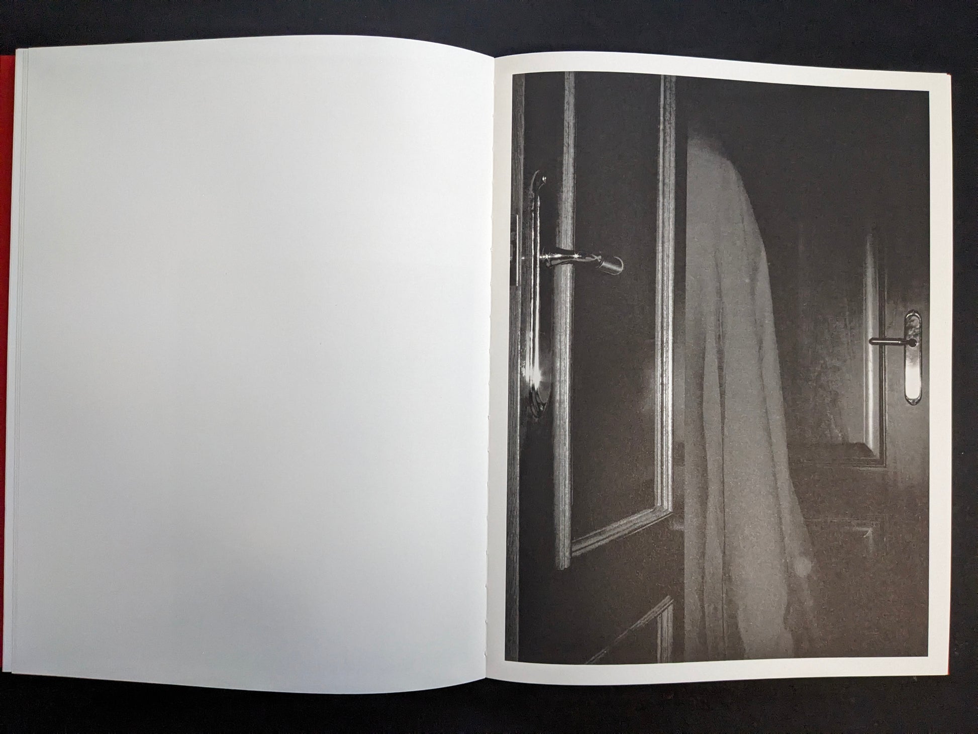 Interior page with a monochrome photograph of a doorway with a hanging cloth or garment.