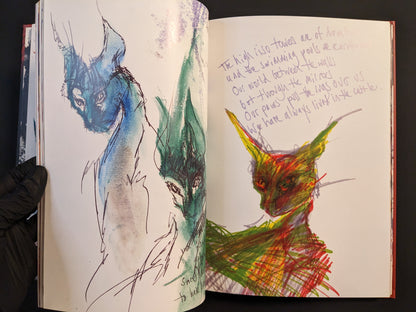 Abstract sketch of mystical animal-like figures with handwritten text