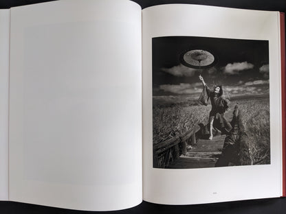 Monochrome image of a performer in traditional Japanese attire holding an umbrella in a dramatic pose.