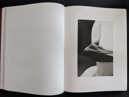 Minimalist black-and-white photograph showing a folded arm and torso composition