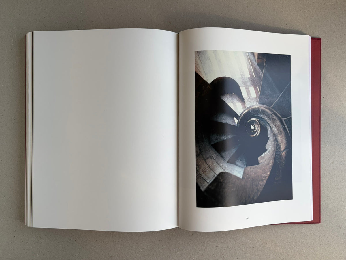 Open Eikoh Hosoe monograph showing a full-page reproduction on the right and a blank left page, with the red hardback cover visible at the edge.