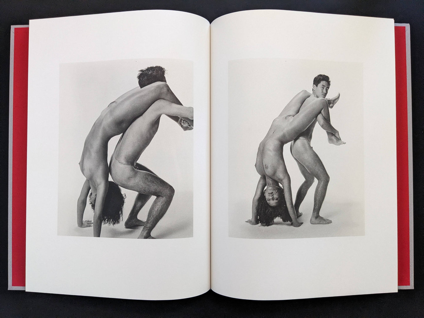 Open spread with two black-and-white nude figures in mirrored poses in Eros Lost.