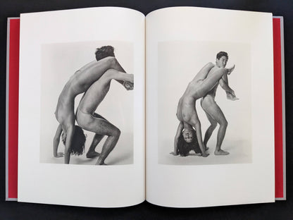 Open spread with two black-and-white nude figures in mirrored poses in Eros Lost.