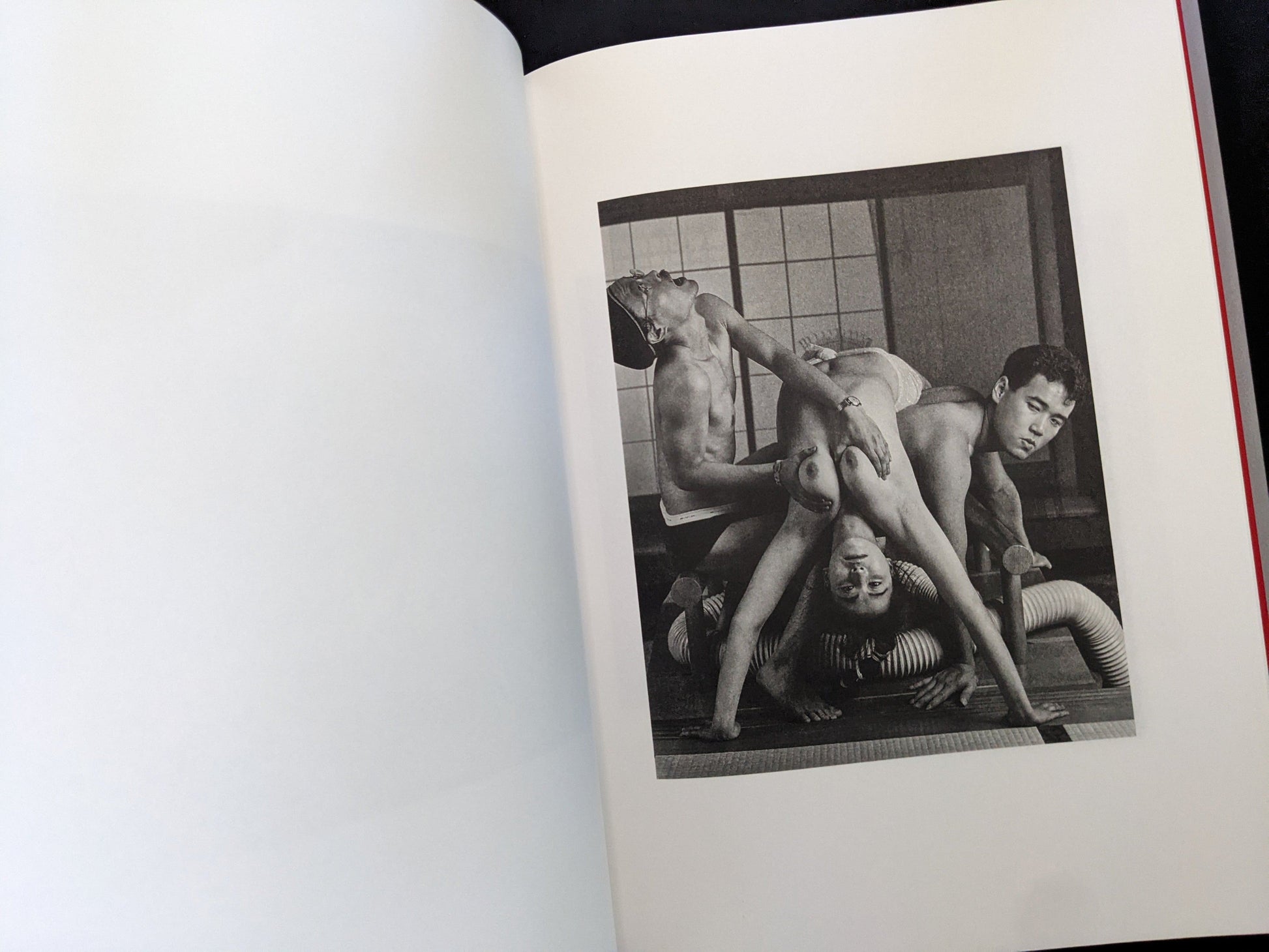 Open spread with a black-and-white group nude scene on the right page in Eros Lost.