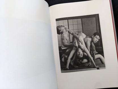 Open spread with a black-and-white group nude scene on the right page in Eros Lost.
