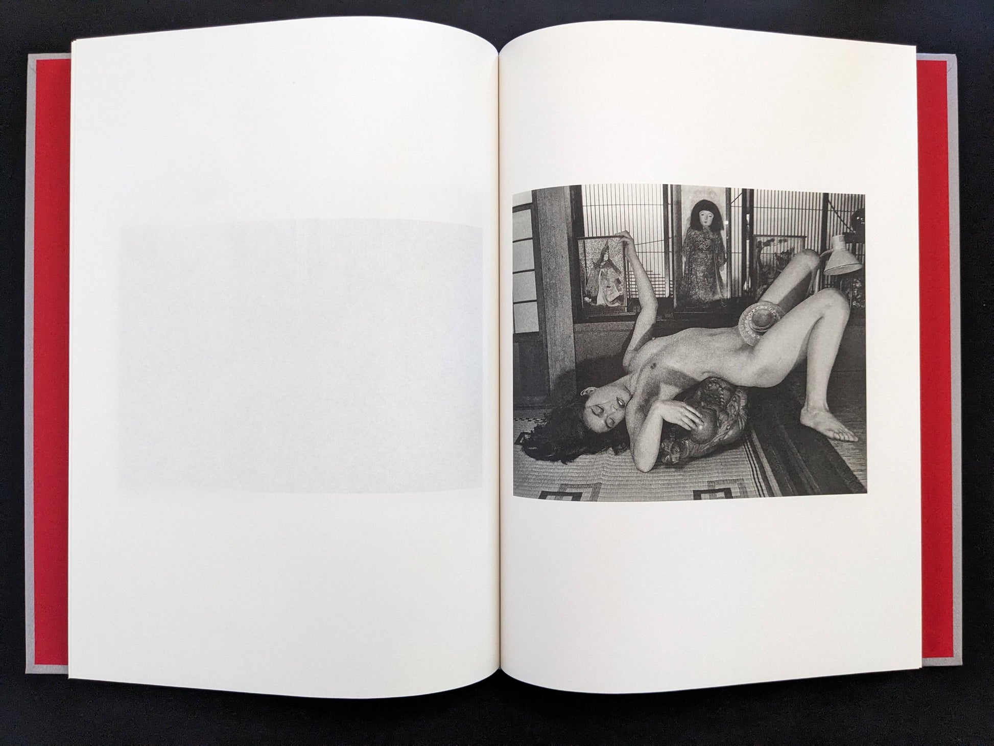 Open spread with a black-and-white nude figure posed in a traditional interior on the right page in Eros Lost.