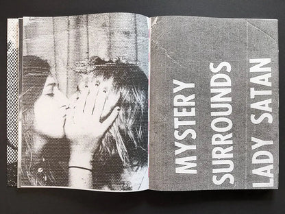 Interior spread from Fishworm pairing the headline “Mystery Surrounds Lady Satan” with a close-up of kissing women.
