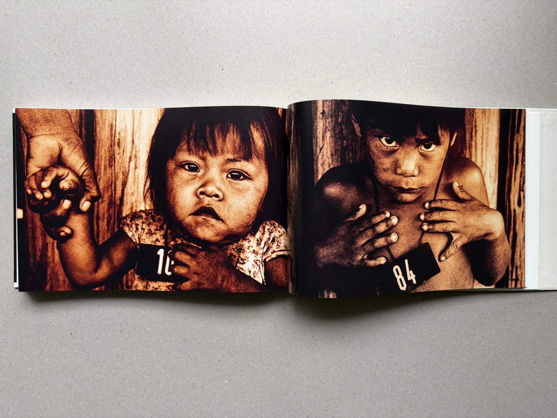 Genocídio do Yanomami by Claudia Andujar, open spread with close-up portraits of two children
