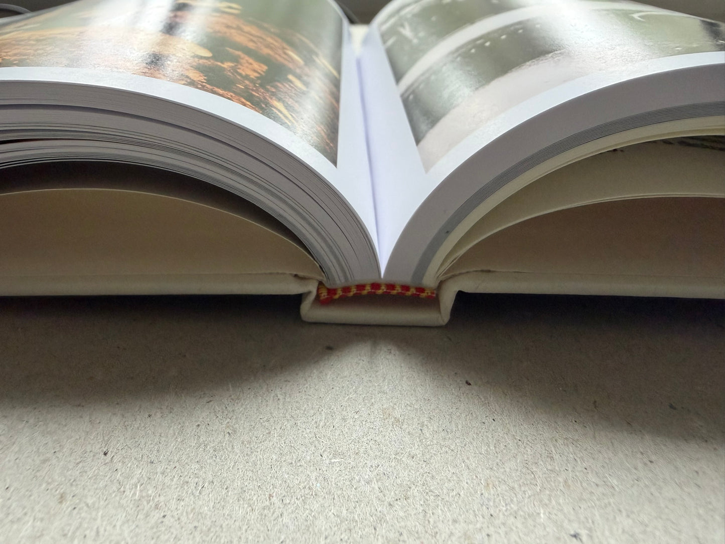 Genocídio do Yanomami by Claudia Andujar, open book showing a spread of colour photographs
