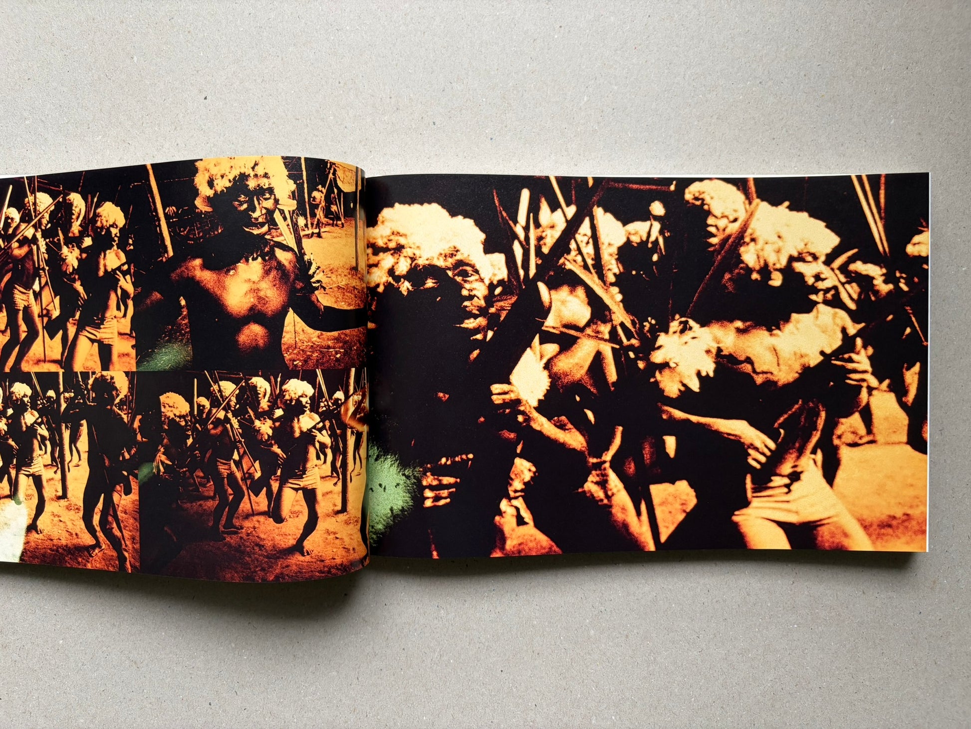Genocídio do Yanomami by Claudia Andujar, open spread with orange-toned photographs of Yanomami figures