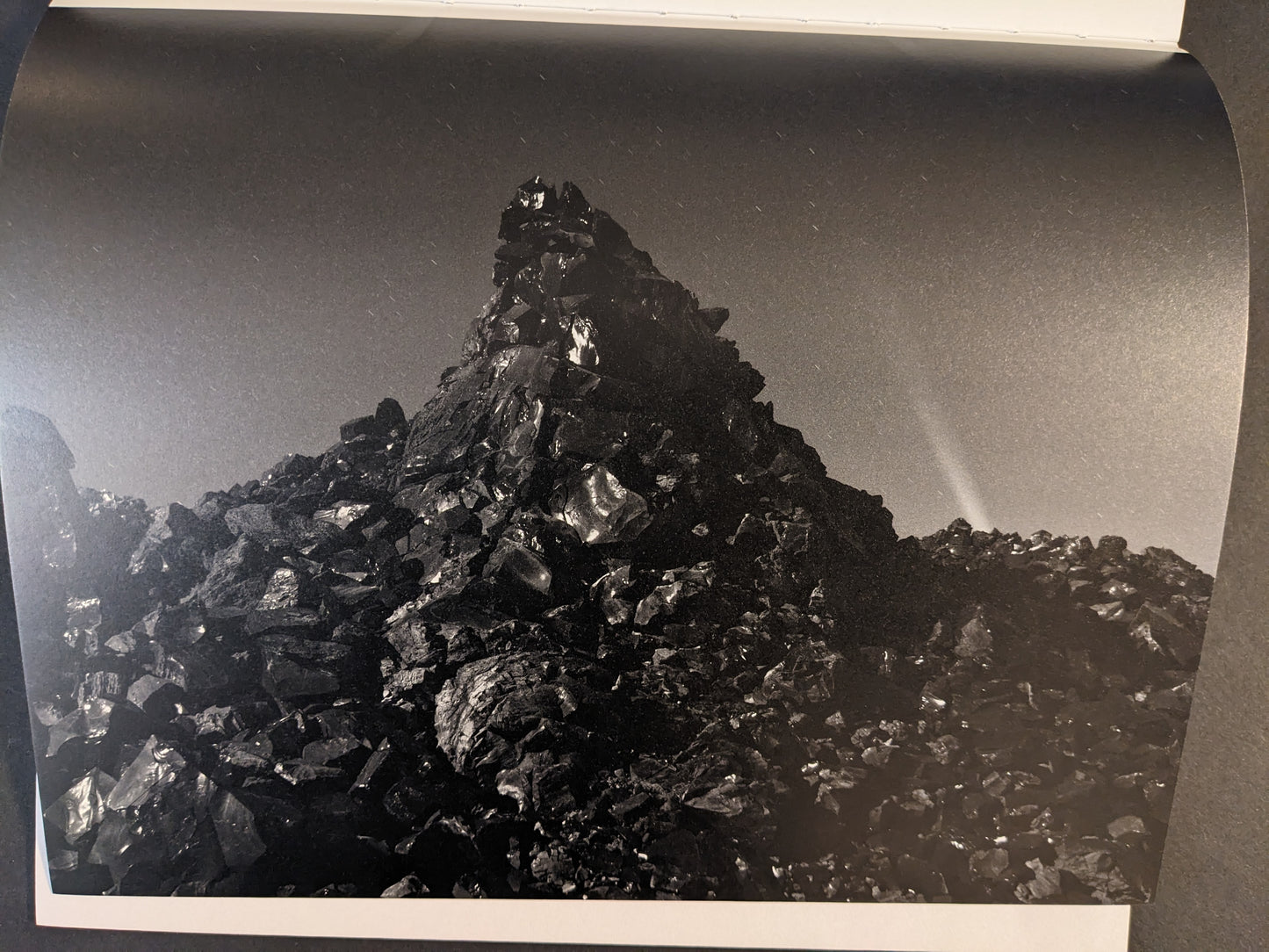 Interior photograph from Glass Mountain by Michael Lundgren, showing a jagged mound of dark rocks under a night sky