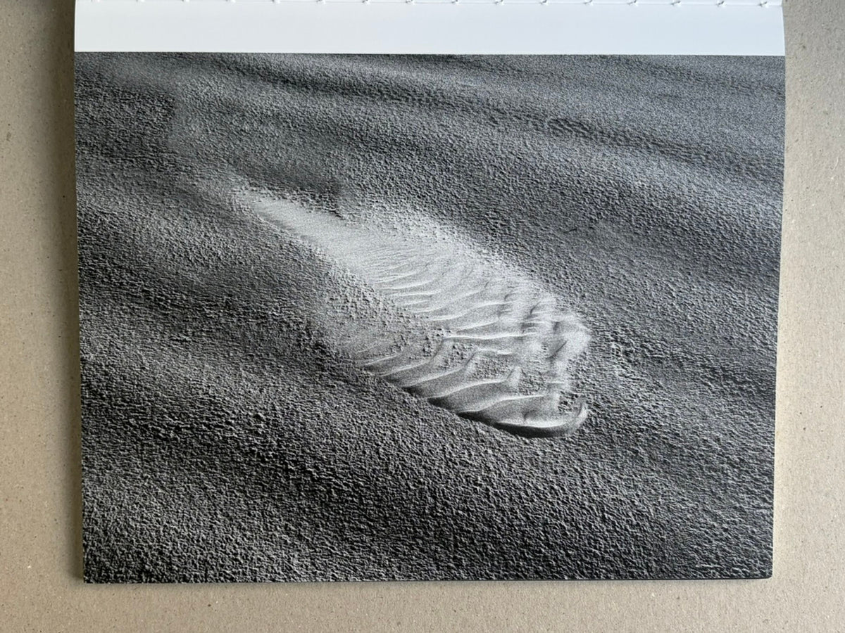 Glass Mountain by Michael Lundgren, open book page showing a black-and-white landscape with a layered rock mound