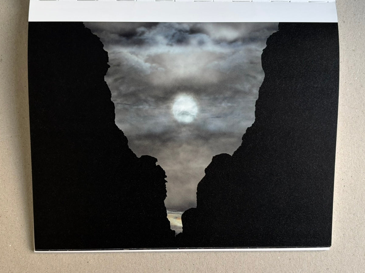 Glass Mountain by Michael Lundgren, open book page with a dark landscape and bare tree trunks