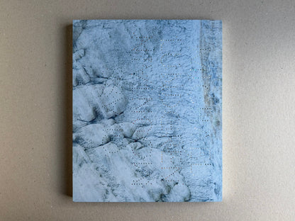 Glass Mountain by Michael Lundgren, open book page showing a blue-toned rock surface with small perforations