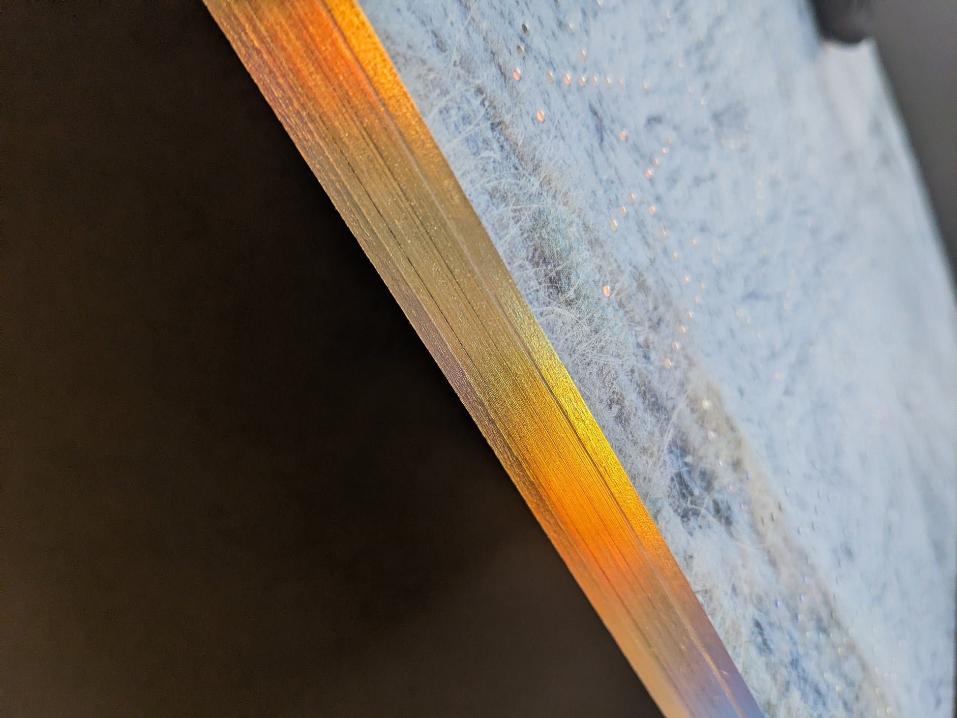 Close-up of Glass Mountain by Michael Lundgren, showing gilded page edges and dotted foil detail on the cover