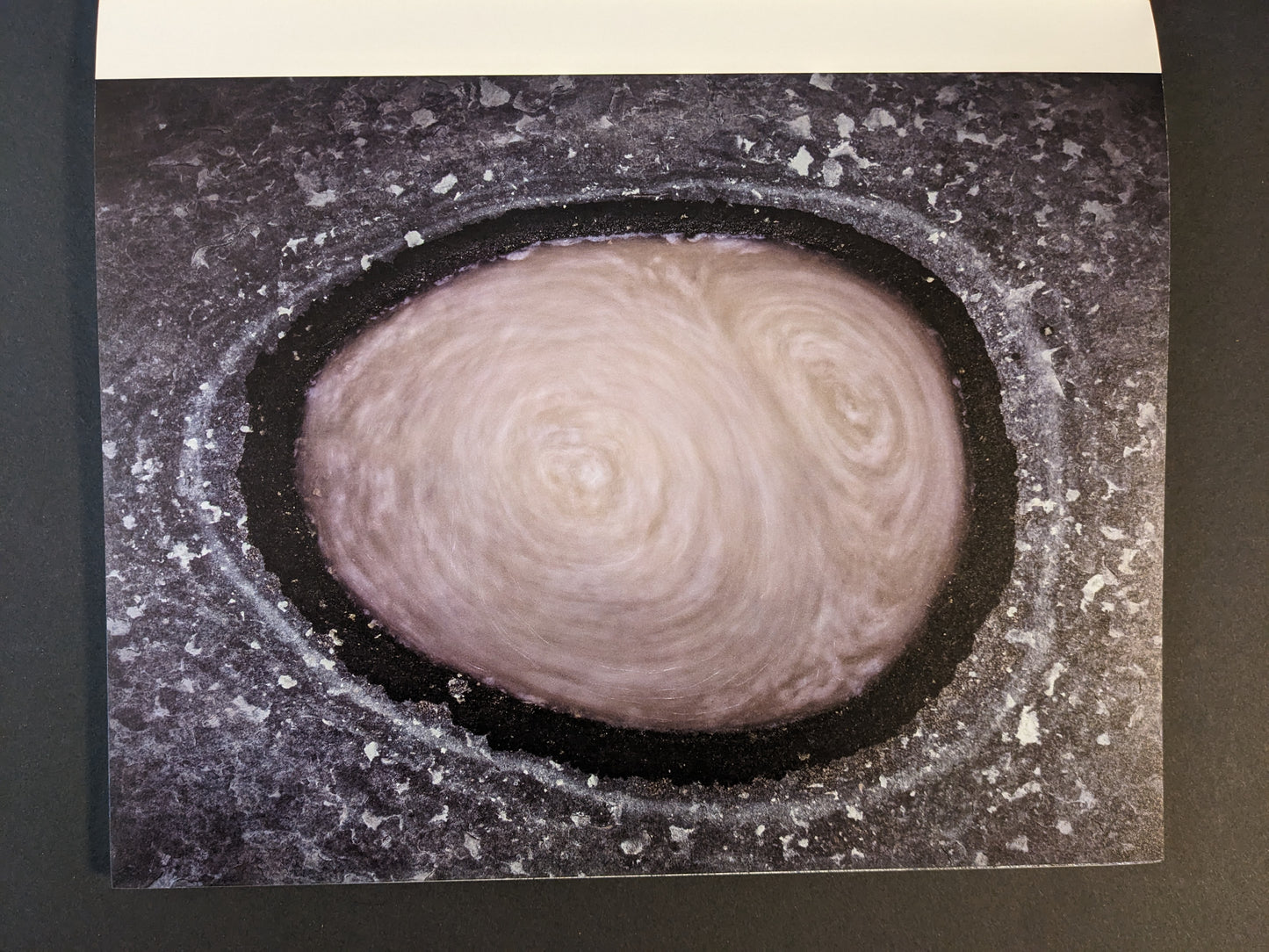 Interior photograph from Glass Mountain by Michael Lundgren, showing a circular pool in rock with swirling water