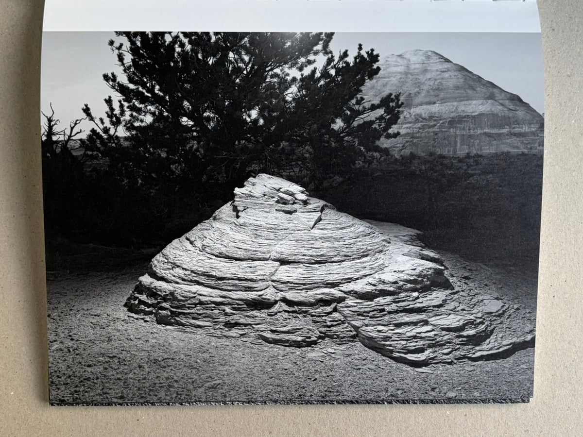 Glass Mountain by Michael Lundgren, open book page showing a layered stone formation in front of a tree and distant mountain