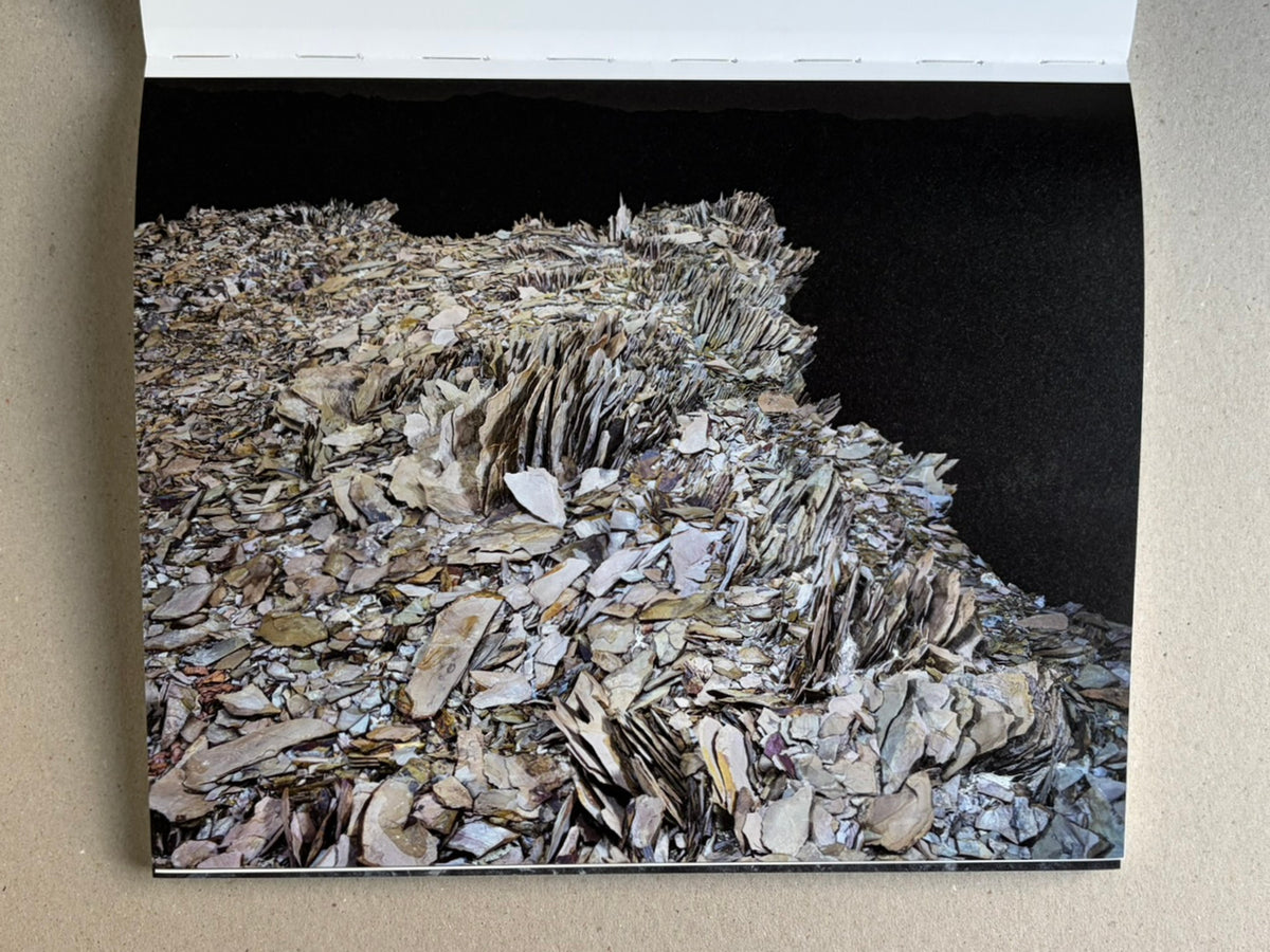 Glass Mountain by Michael Lundgren, open book page showing a layered rock formation against a black background