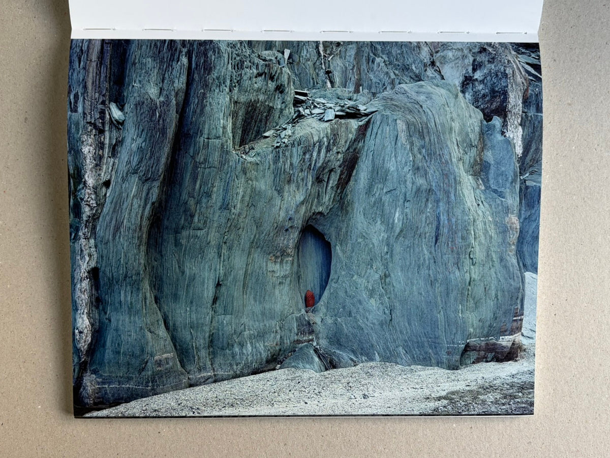 Glass Mountain by Michael Lundgren, open book page showing a blue rock face with a small red detail