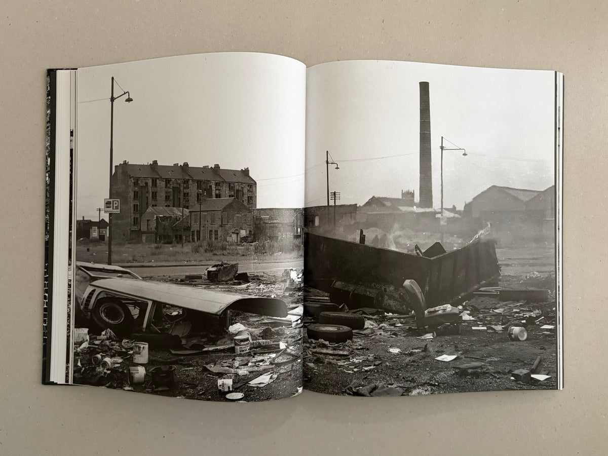 Open spread from Gorbals – Peter Christopherson showing a black-and-white urban landscape with derelict buildings, a tall chimney, street lamps, and debris in the foreground.
