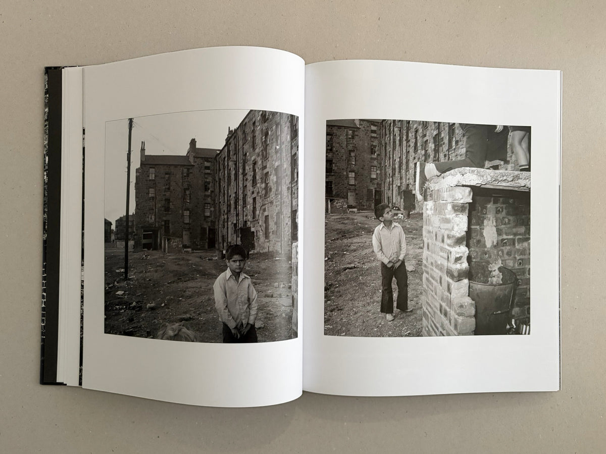 Open book spread from Gorbals by Peter Christopherson, showing two black-and-white photographs of a boy in a derelict urban setting.