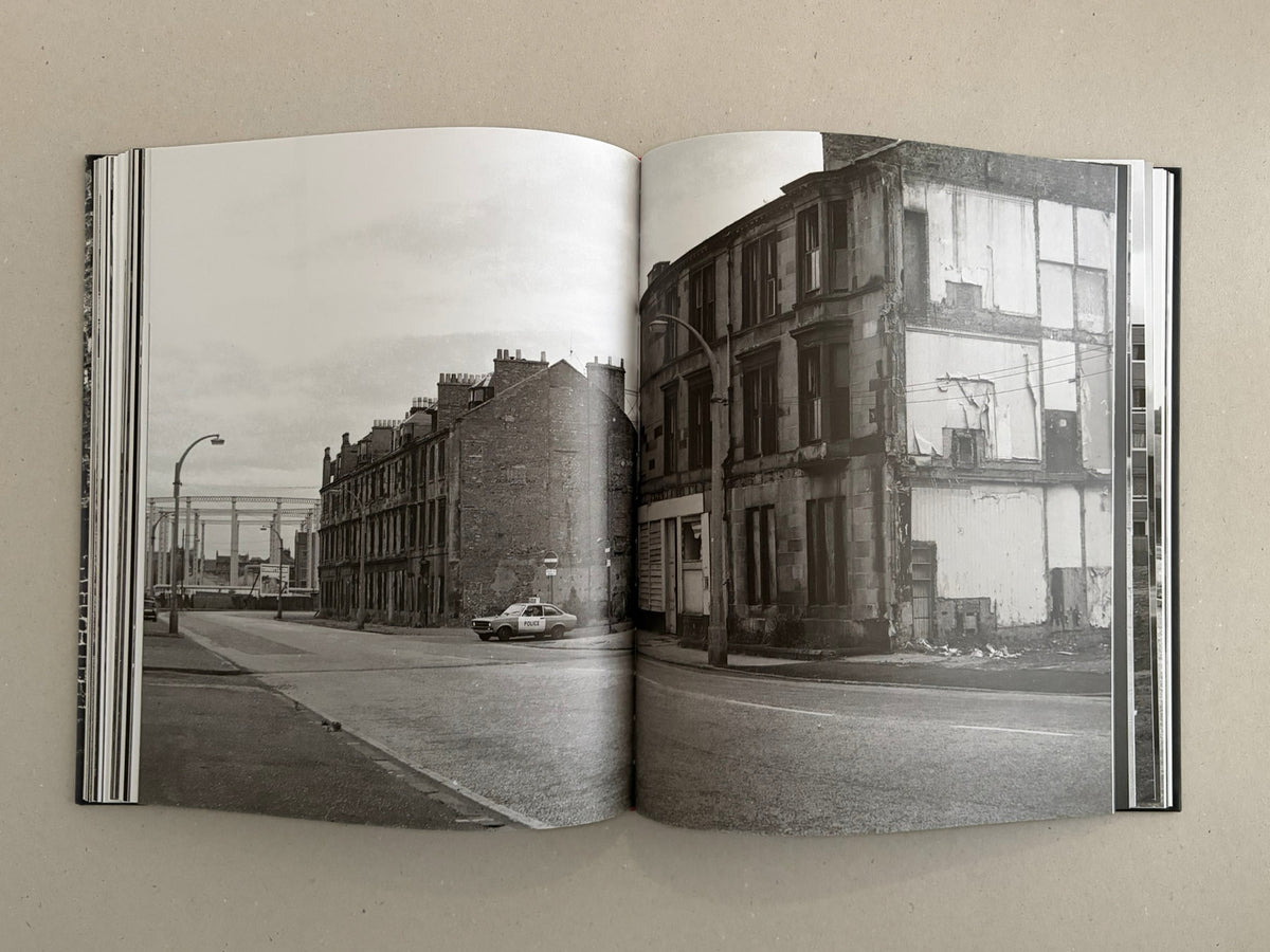 Open spread from Gorbals by Peter Christopherson, showing a black-and-white street scene across two pages with derelict buildings and a police car.