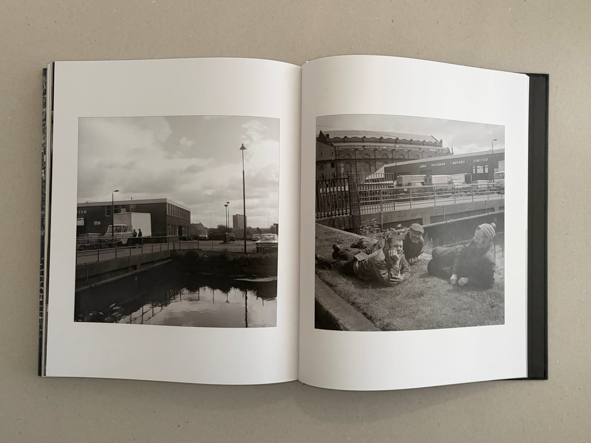 Gorbals – Peter Christopherson open to a two-page spread of black-and-white photographs, showing an urban canal scene on the left and three people lying on grass on the right.