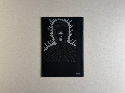 Back cover of Grayworld with a silver monster face and price mark on black paper