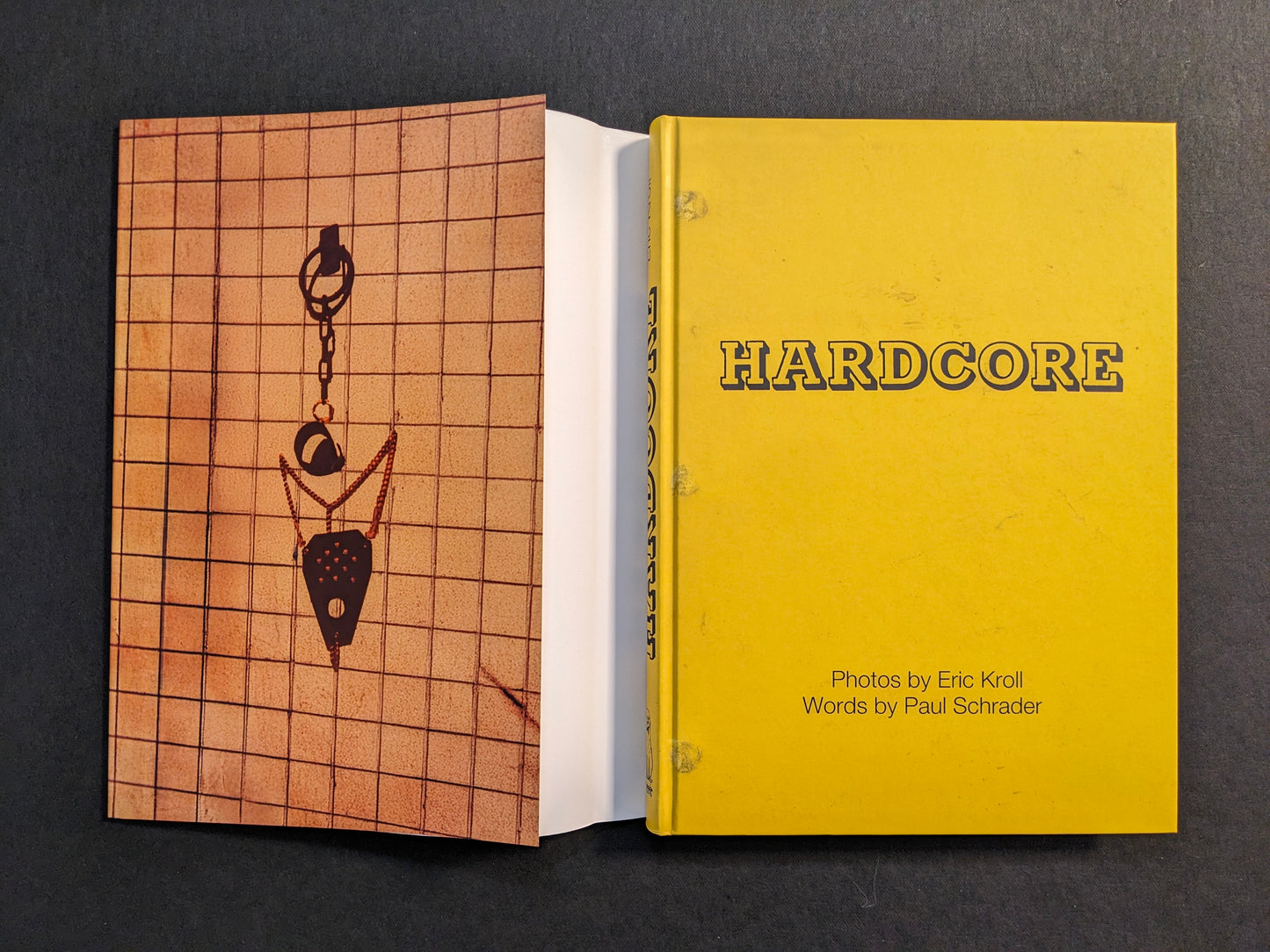 Book shown with dust jacket removed, revealing the yellow cloth cover of “HARDCORE” and the printed dust jacket.