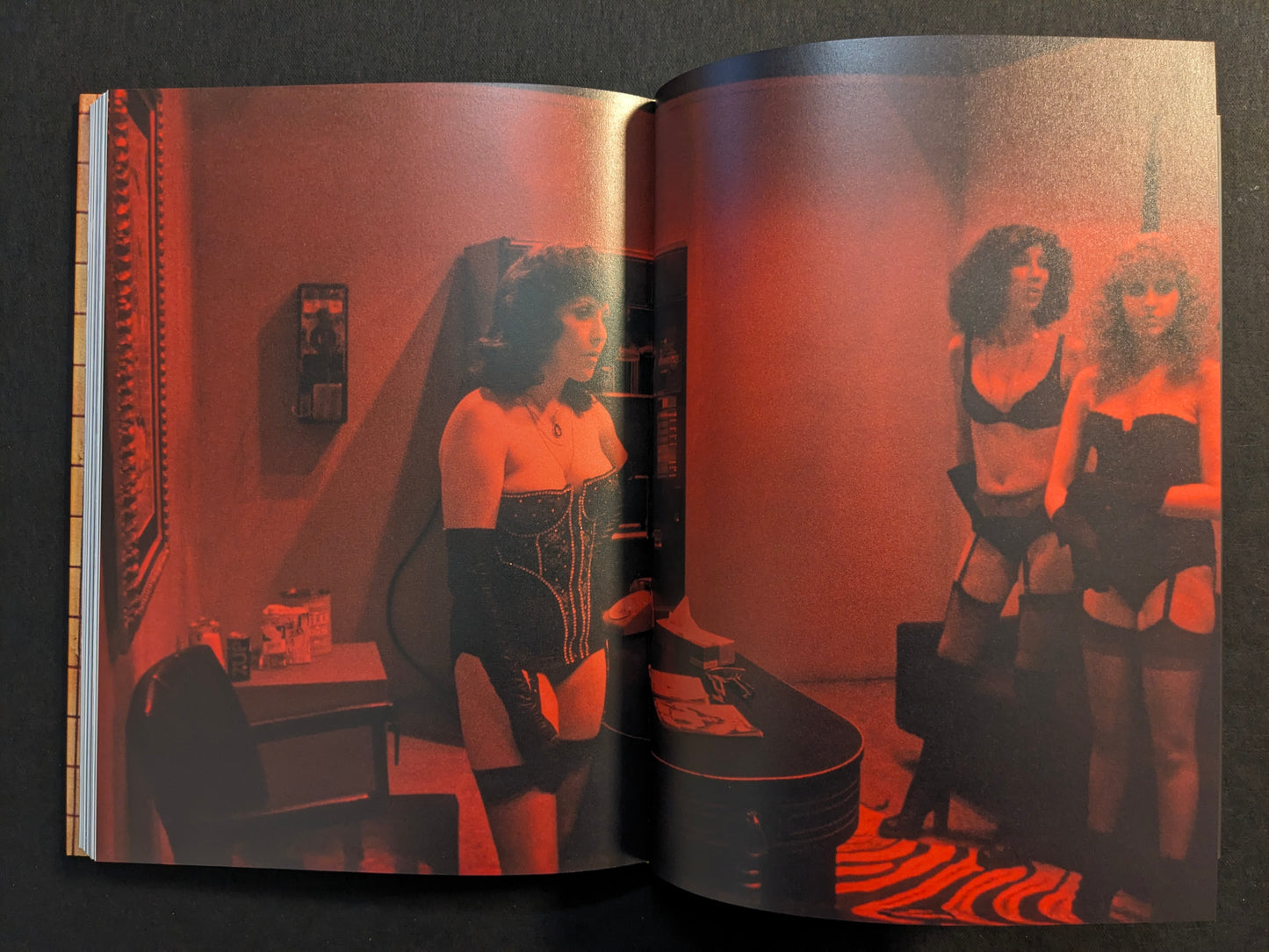 Red-lit interior scene with performers in lingerie (adult content), from “HARDCORE” by Eric Kroll (Timeless Edition).