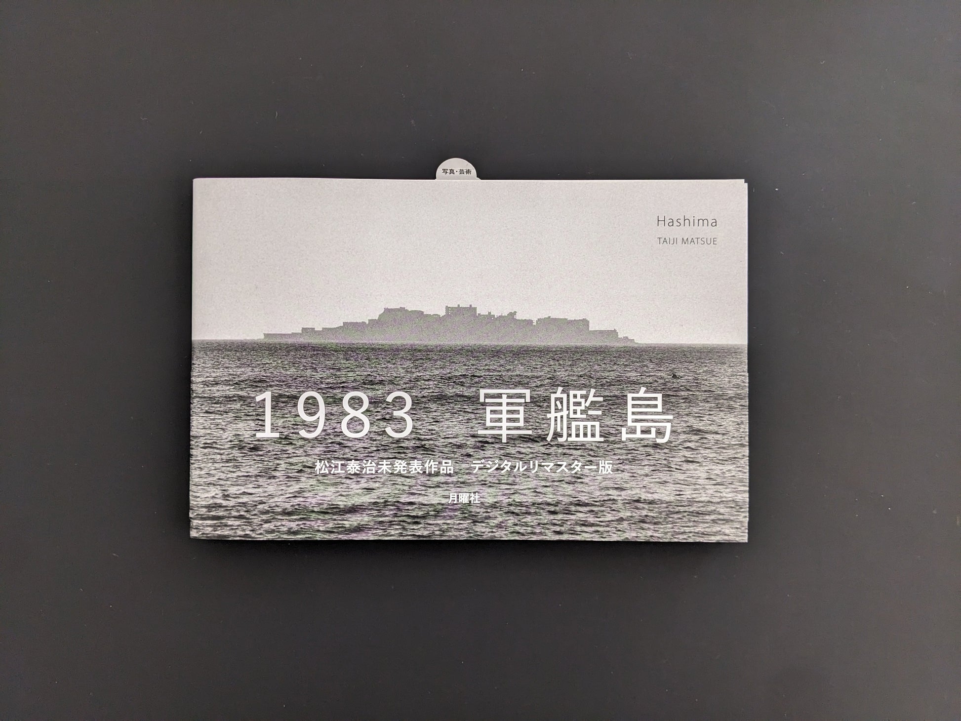 Front cover of Hashima by Taiji Matsue with silhouette of Gunkanjima Island and Japanese title