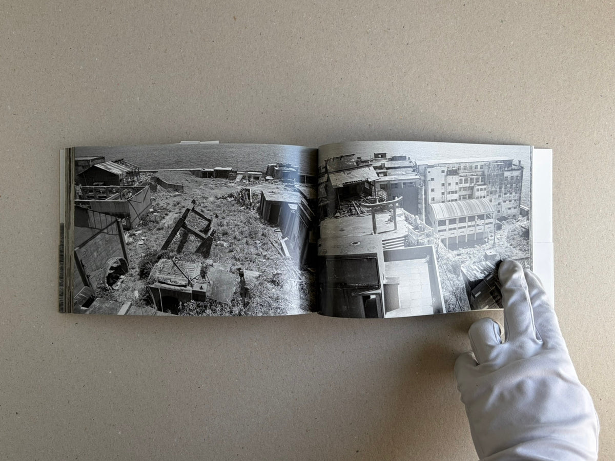 Open spread of Hashima by Taiji Matsue, showing black-and-white photographs of abandoned buildings on Hashima Island.